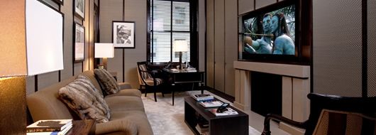 Luxury home theater lounge with custom plush seating, optimized viewing angles, and acoustic paneling for superior film and sports entertainment